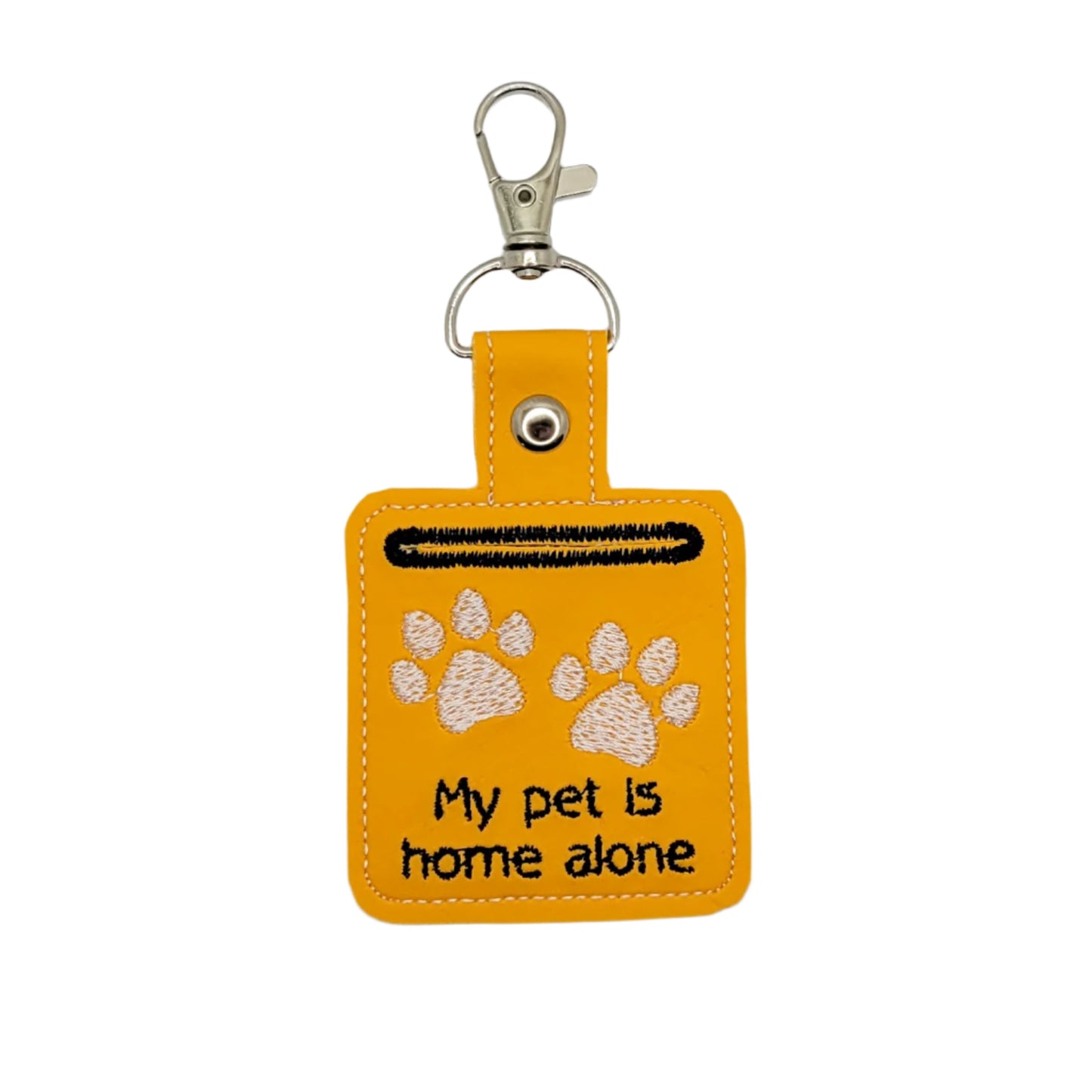 Yellow keychain with paw prints and text 'My pet is home alone' on a light gray background