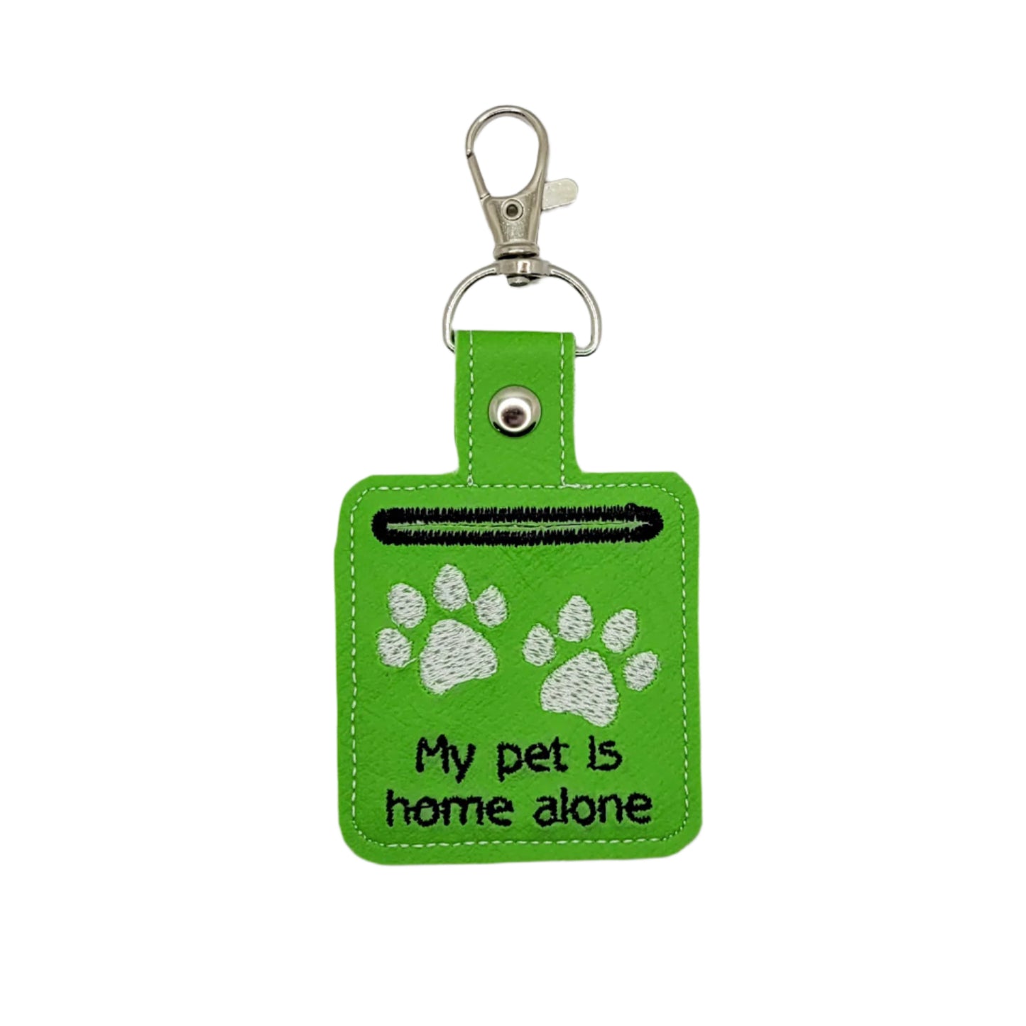Green keychain with paw prints and text on a gray background