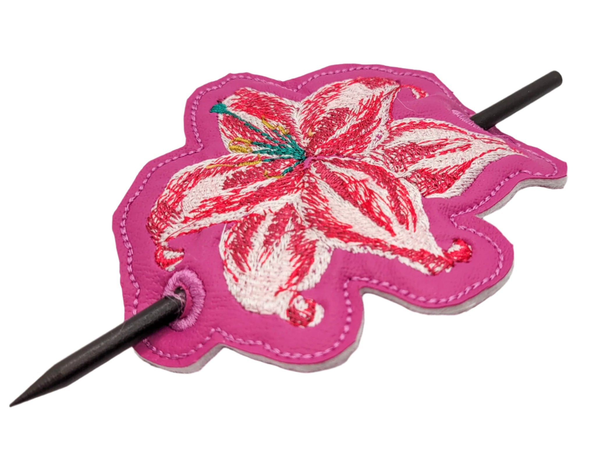 Floral embroidered hair clip on a marble background