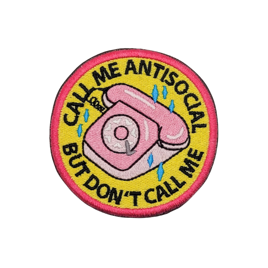 A pink embroidered patch with a telephone design and the text 'Call me antisocial but don't call me'.