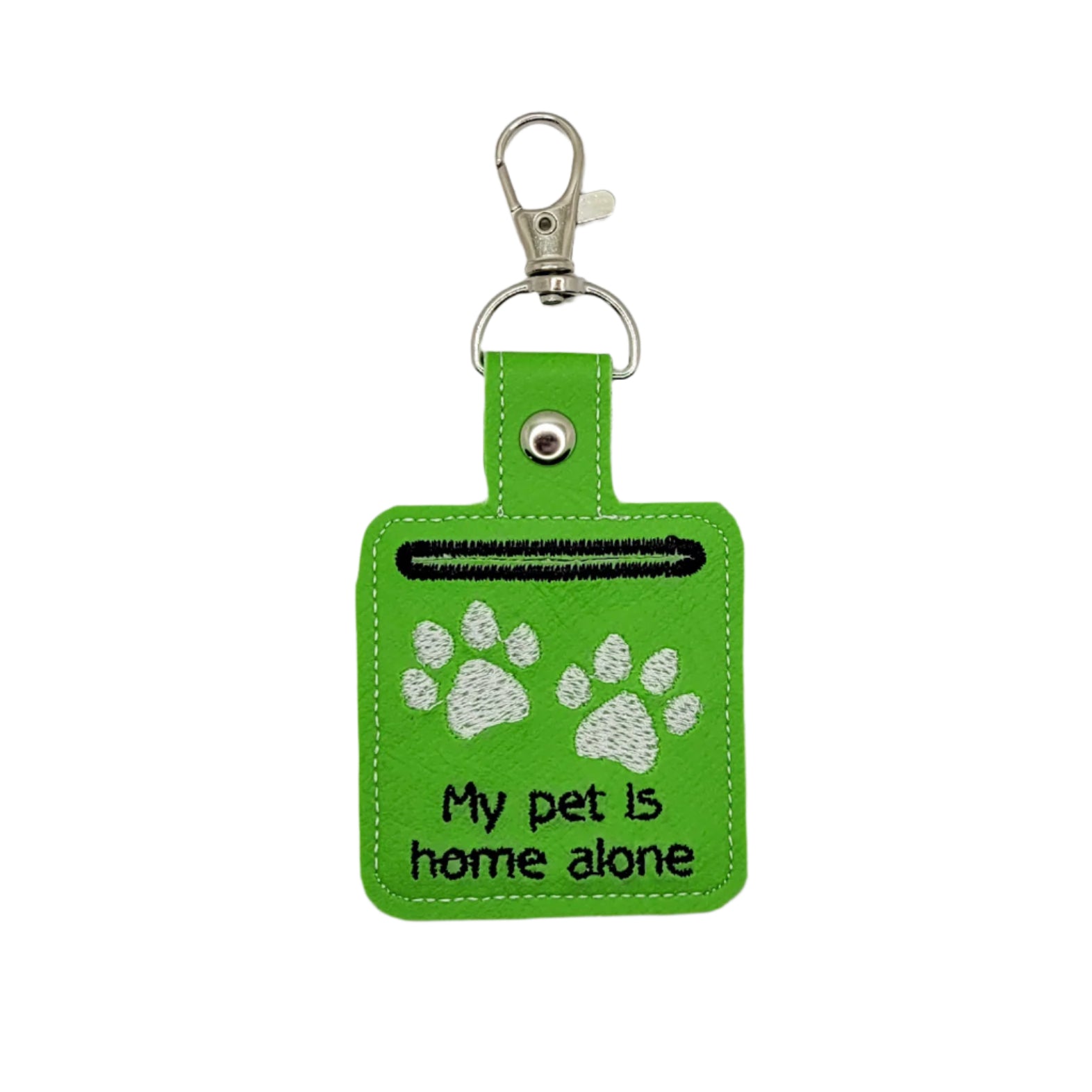 Green keychain with paw prints and text on a gray background