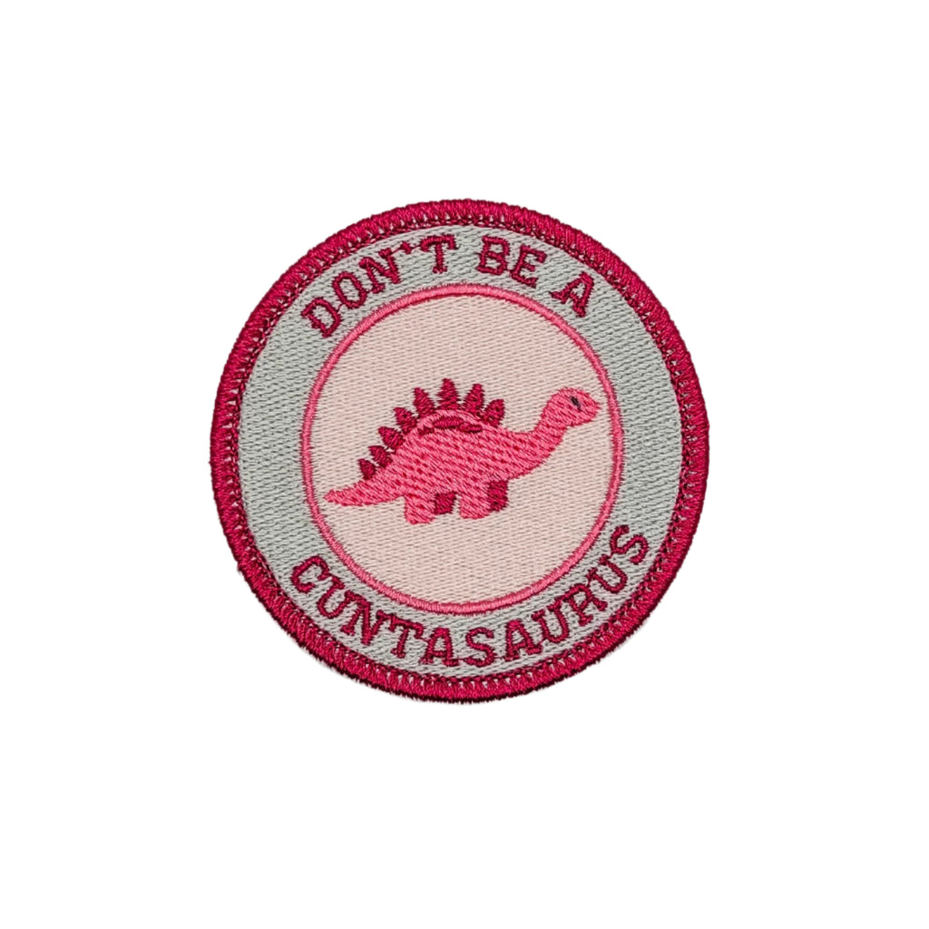 A collection of circular iron-on patches with the text 'DON'T BE A CUNTASAURUS' and a dinosaur motif in various colors.