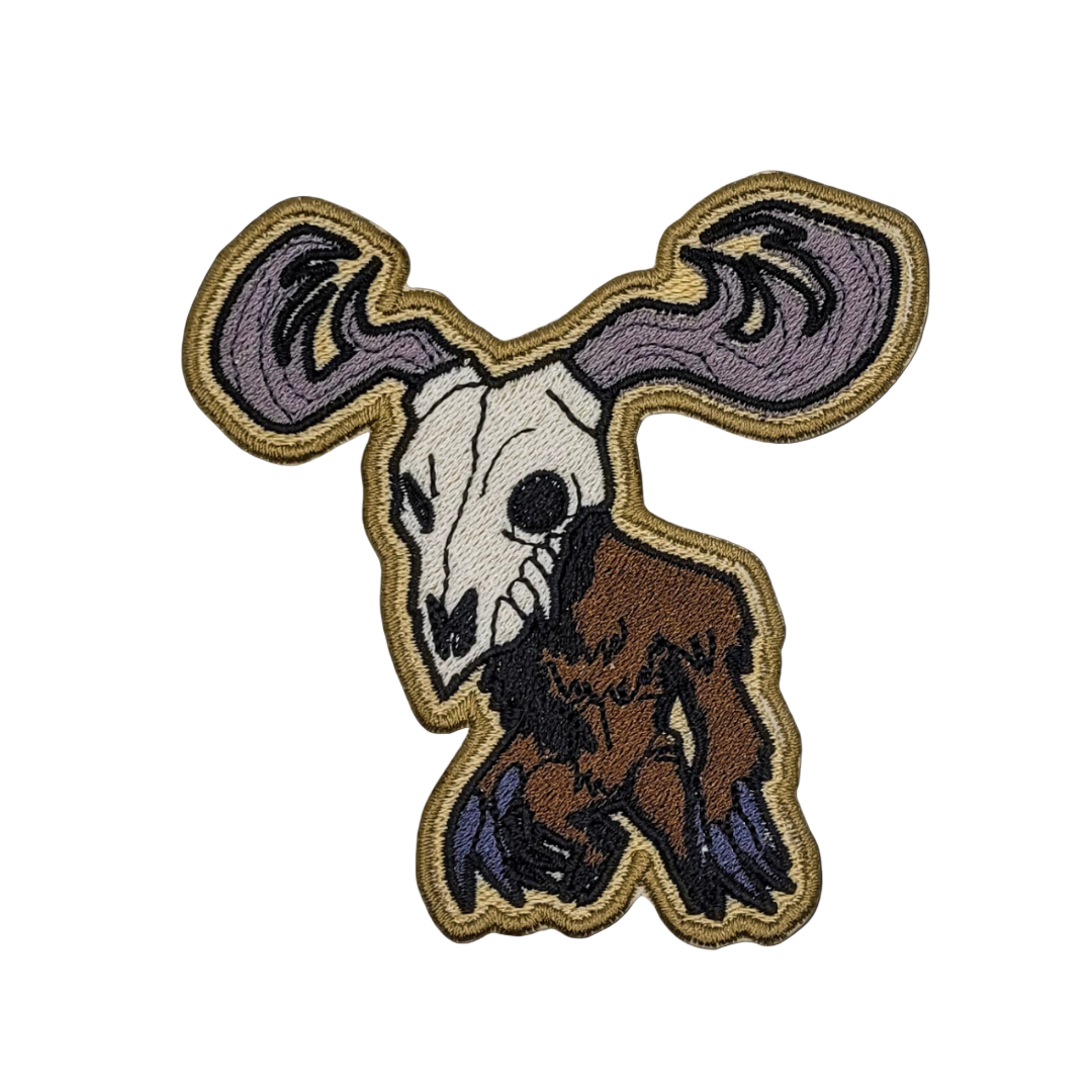An embroidered patch depicting a wendigo with a skeletal face, antlers, and a brown body on a black background.