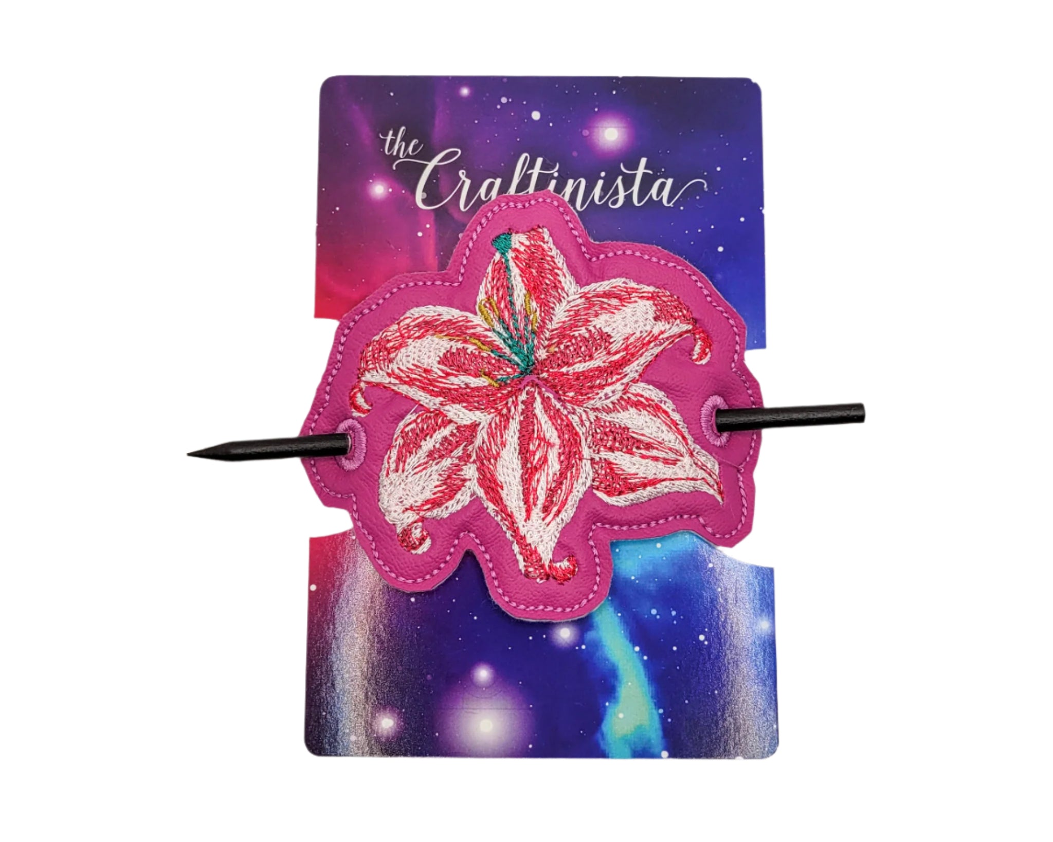 Decorative hair clip with pink flower design on a 'The Craftinista' branded card against a marble background