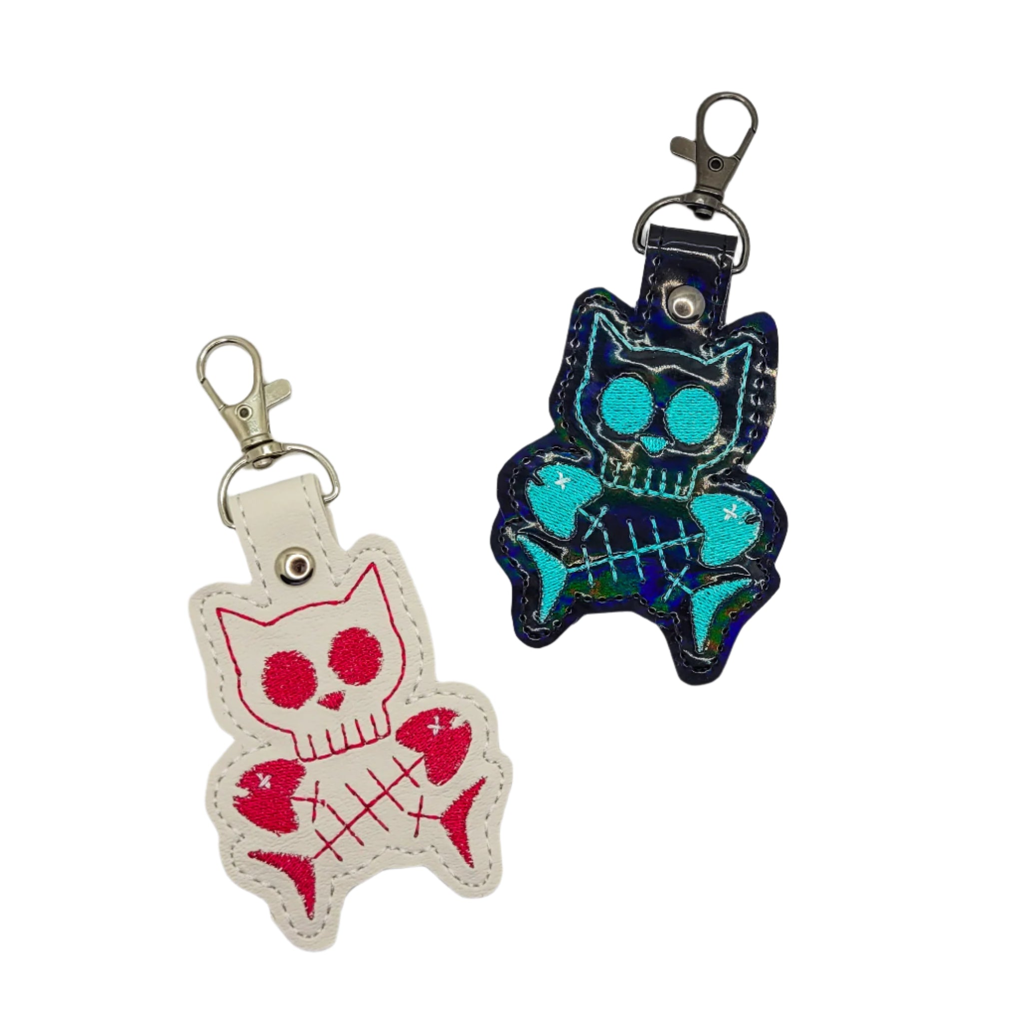 Two cat-shaped keychains on a light gray background