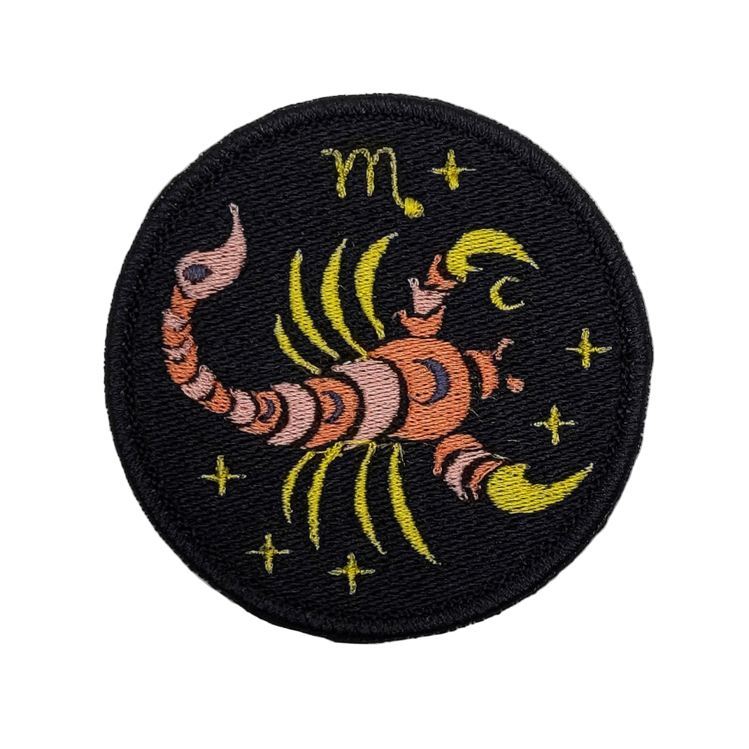 Embroidered patch of a scorpion with star patterns on a black background