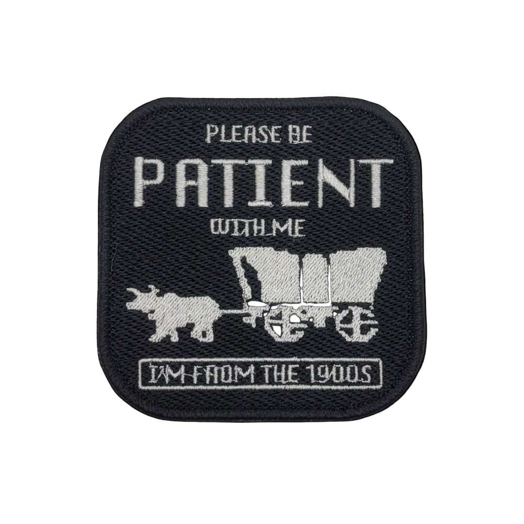 A black embroidered patch with a vintage design, including a wagon and the text 'Please be patient with me, I'm from the 1900s'.