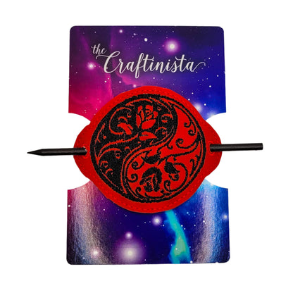 Embroidered bun cover with black floral yin yang design on red marine vinyl, secured with black wooden hair stick