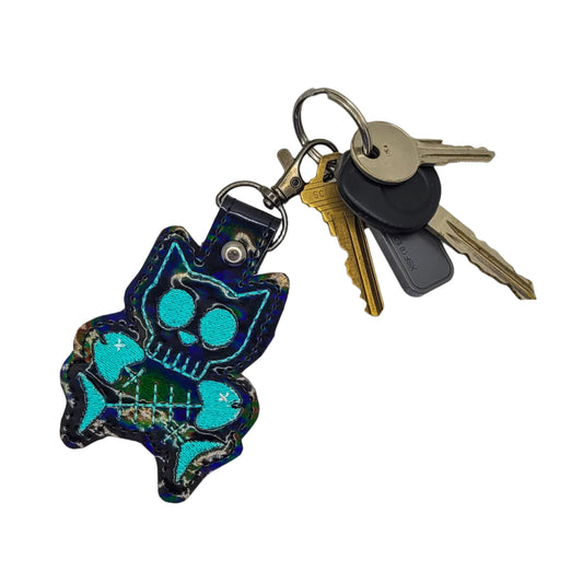 Keychain with blue cat design and keys on a white background