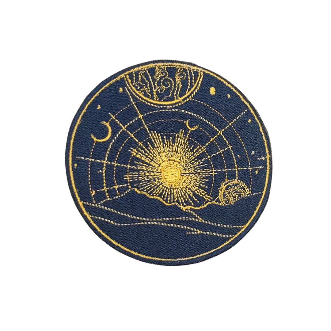 Circular patch with celestial design featuring sun, moon, and stars on a blue background