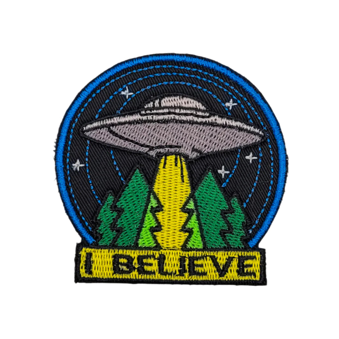 Embroidered patch with UFO and trees design on a white background.