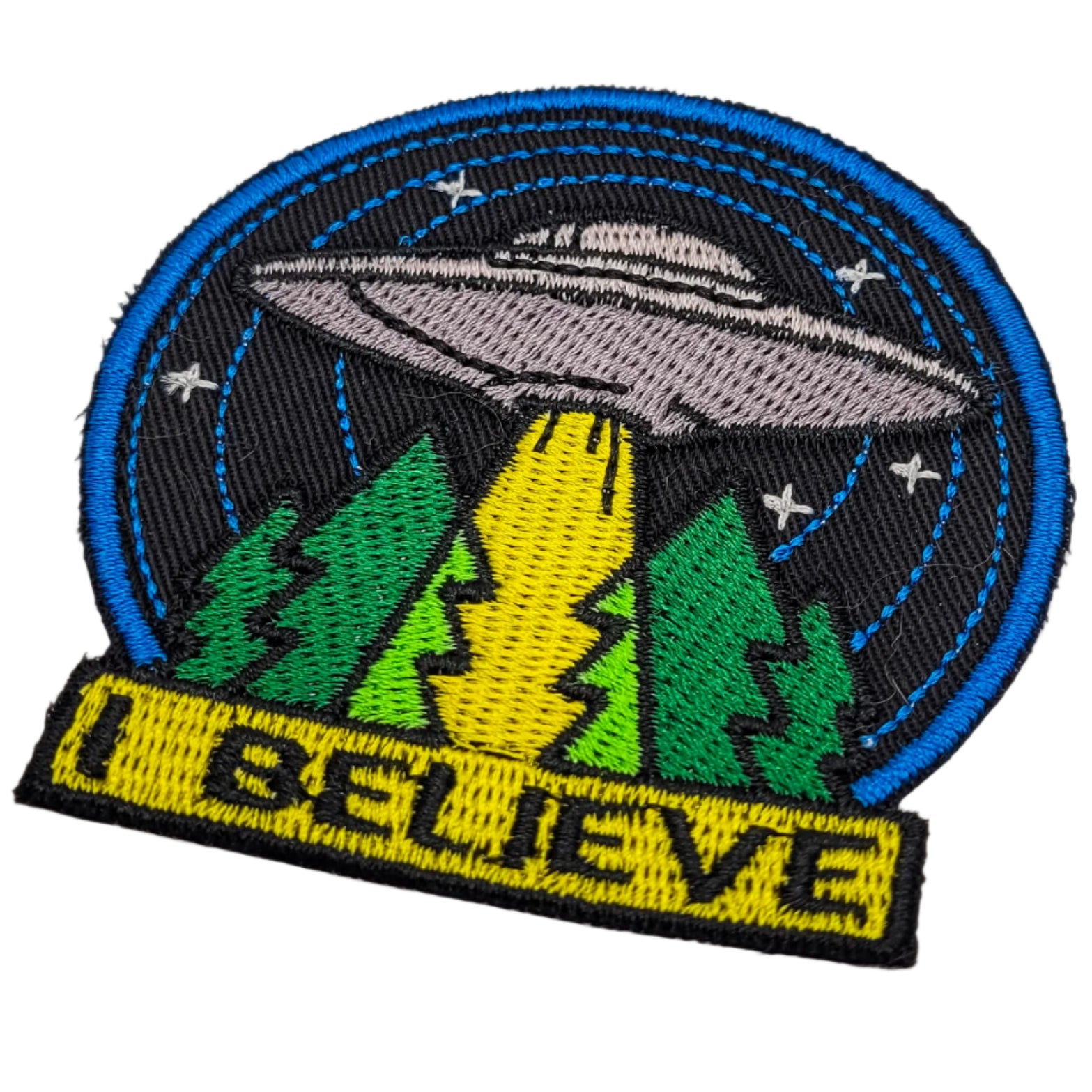 Embroidered patch with UFO over a forest design on a white background