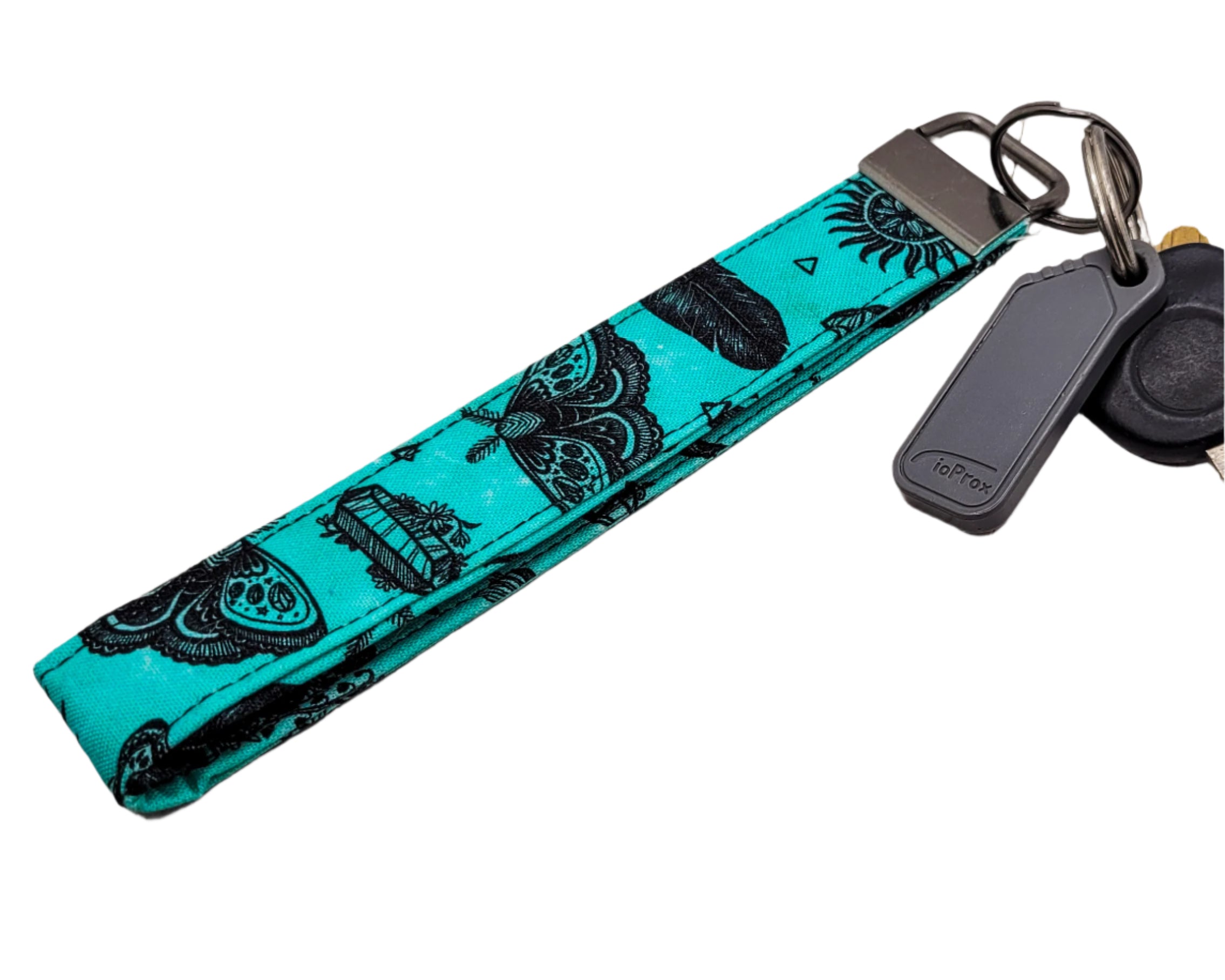 Turquoise key fob with black butterfly  and crystal pattern on a white background.