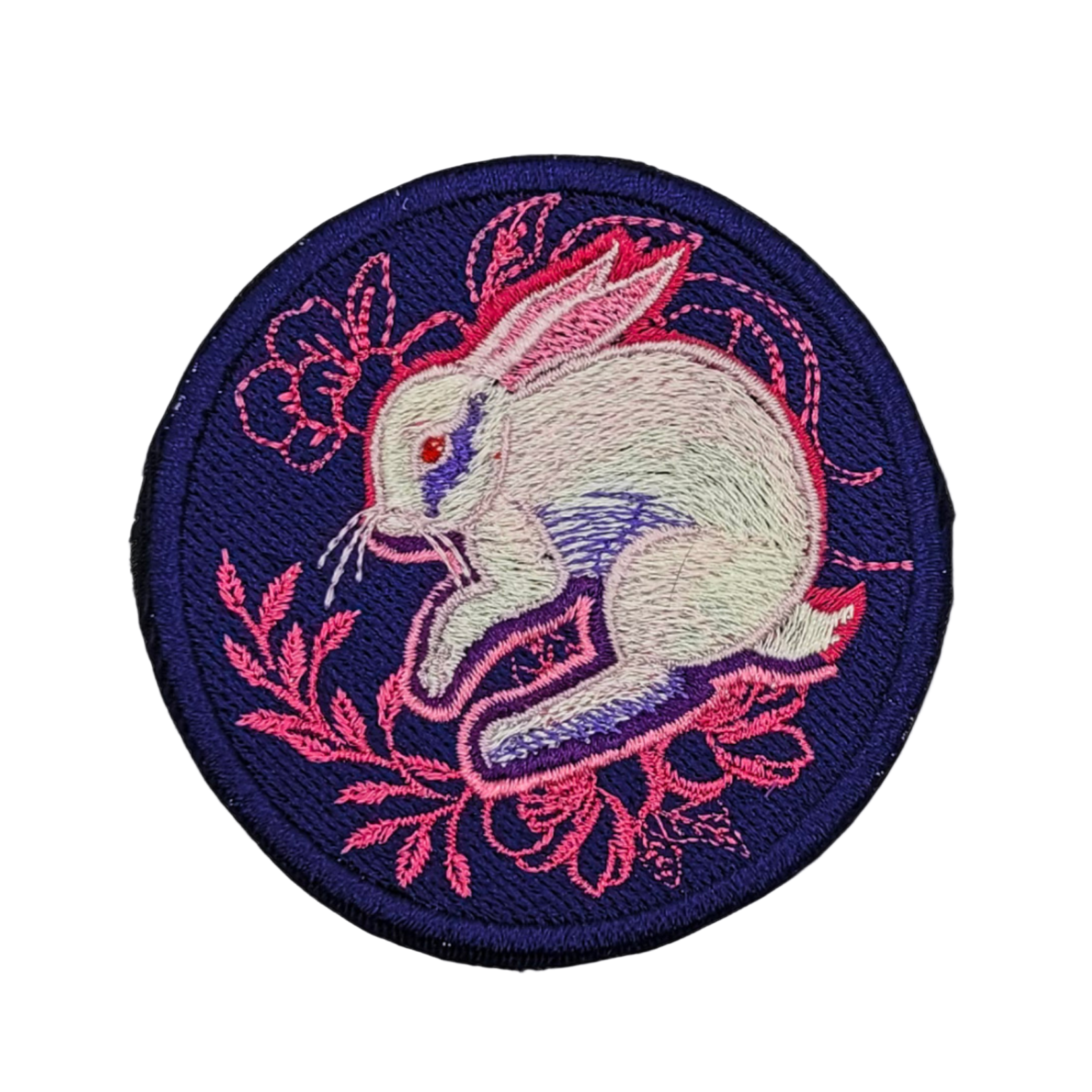 A round embroidered patch featuring a white rabbit with pink ears and a pink floral border.