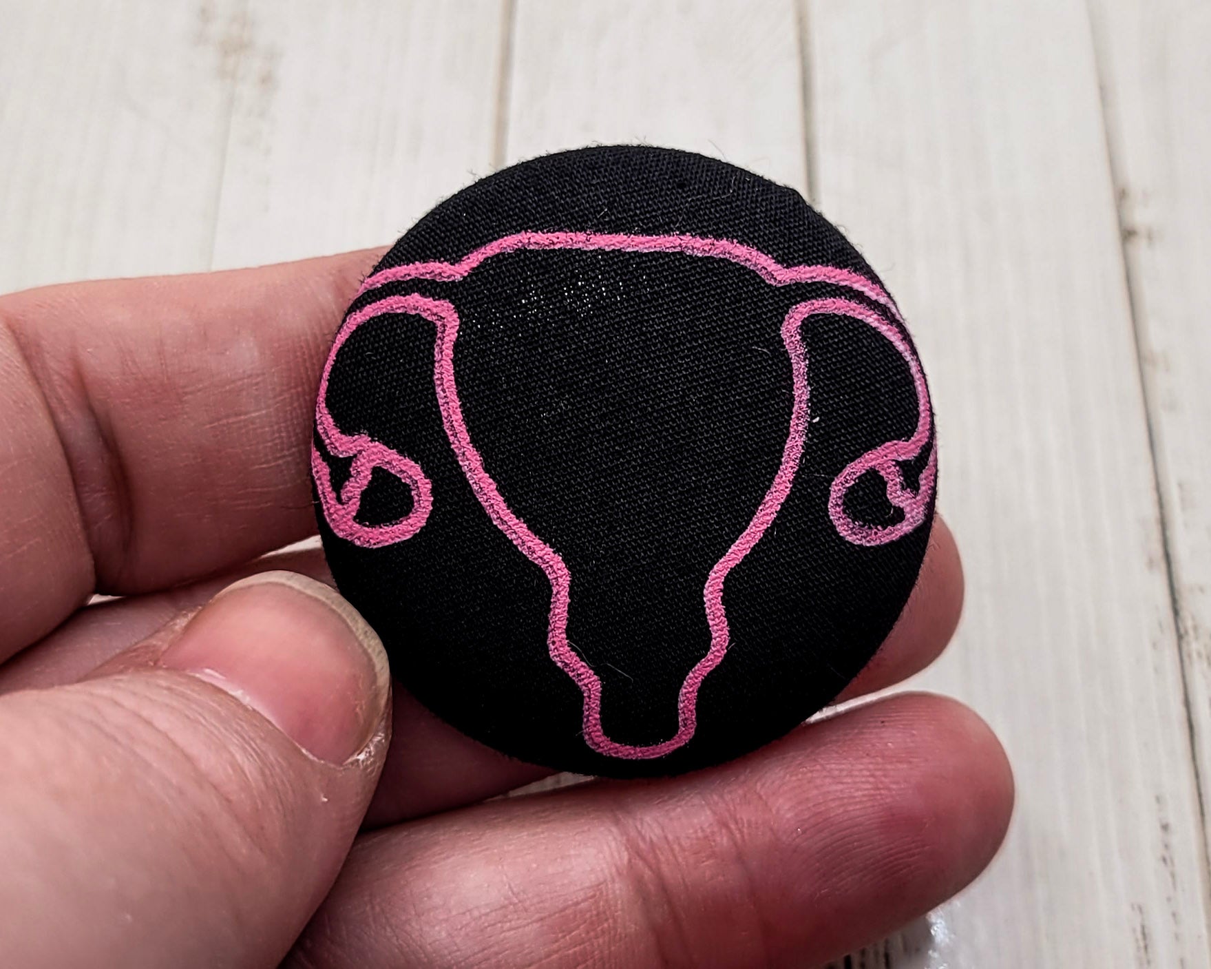 Pin de tela con forma de útero