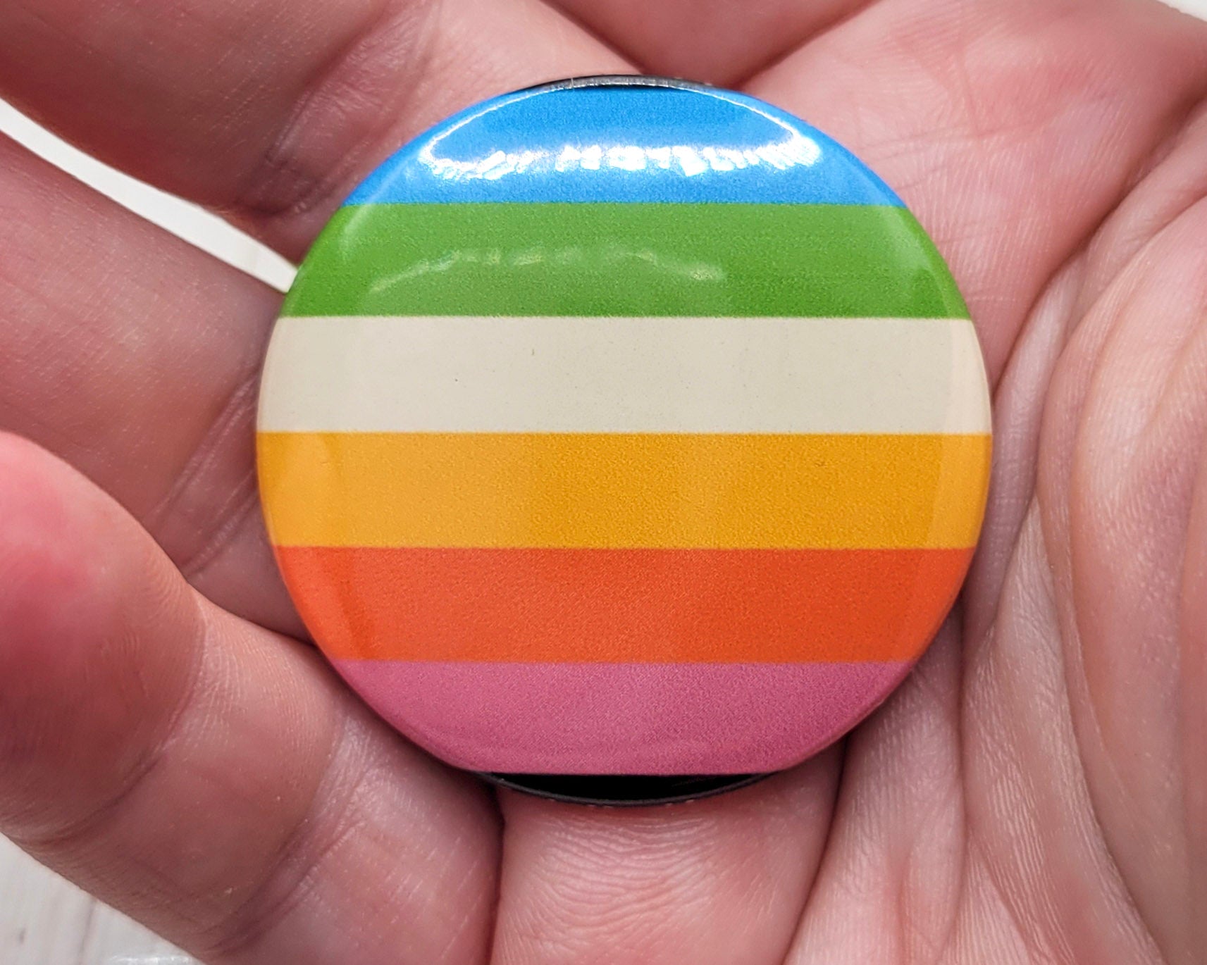 Botón con la bandera queer