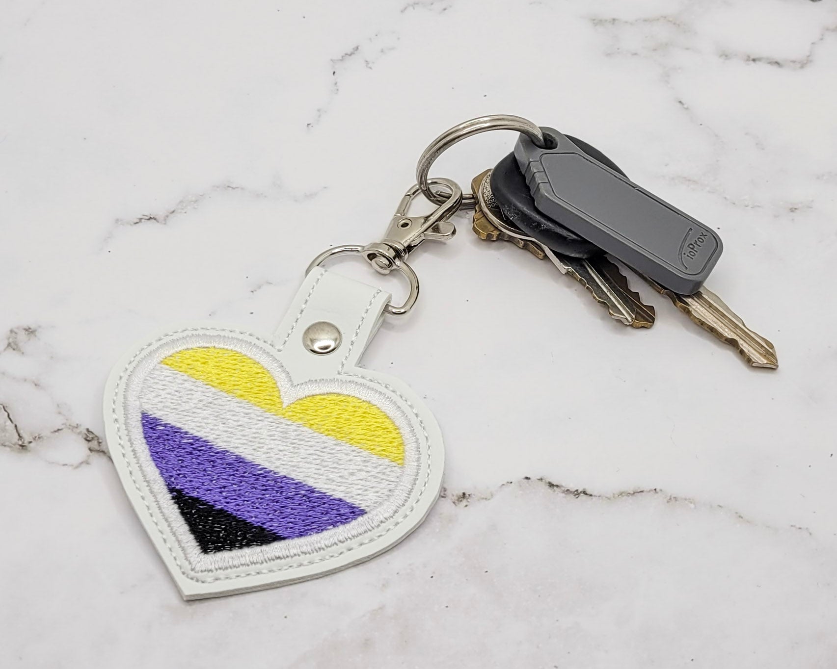 Porte-clés en vinyle avec drapeau non binaire en forme de cœur