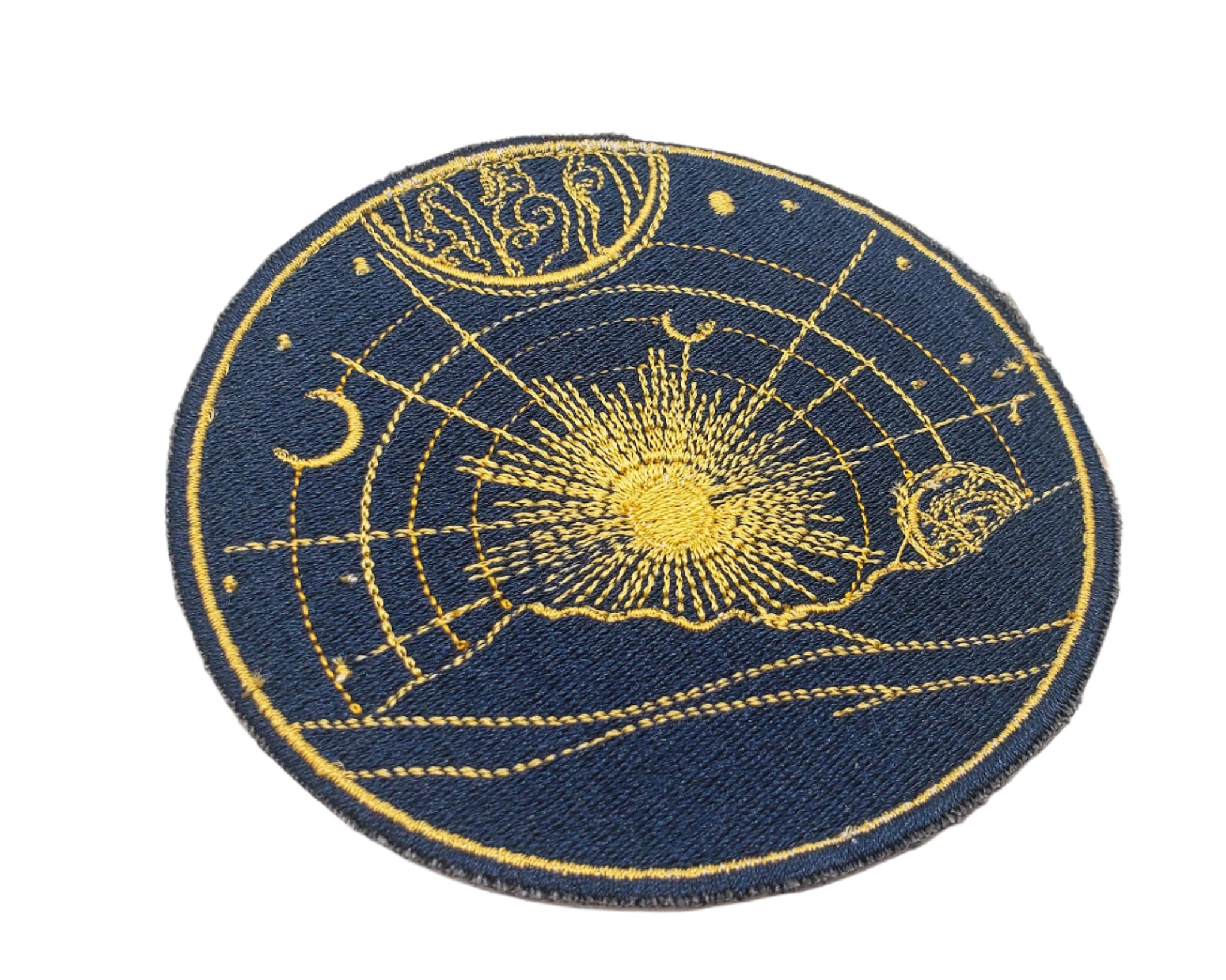 Round patch with celestial design featuring sun, moon, and stars on a blue background.