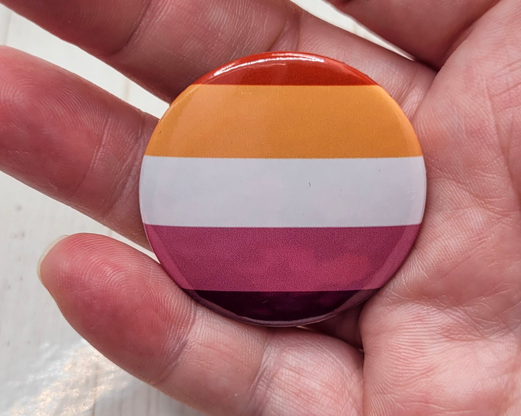 Botón con la bandera del orgullo lésbico